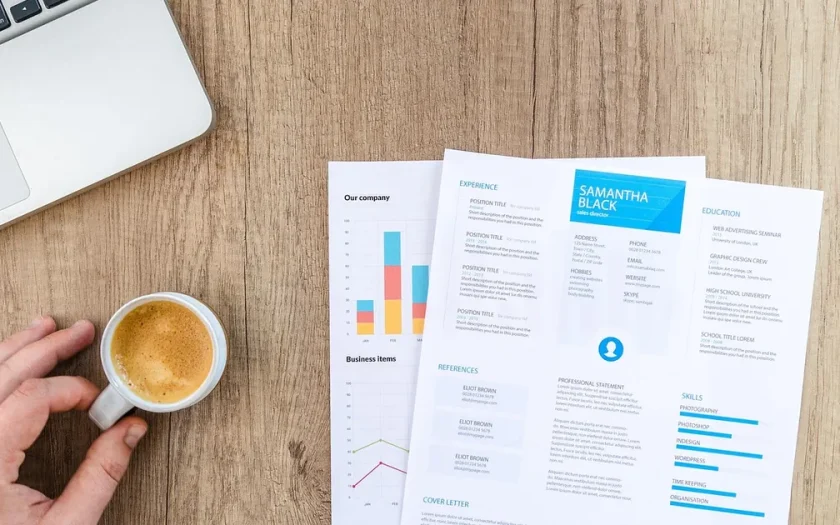 Person skriver CV på dator vid skrivbord