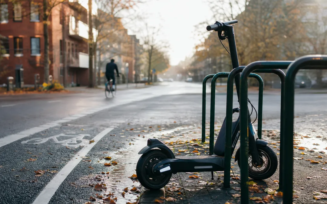 Elsparkcykel parkerad vid cykelställ på svensk gata